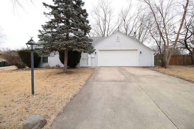 single story home featuring concrete driveway, an attached garage, and fence