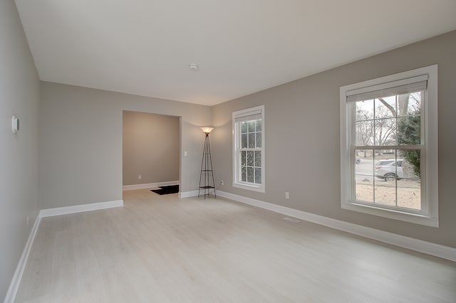spare room with light wood finished floors and baseboards