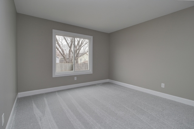empty room featuring baseboards and carpet