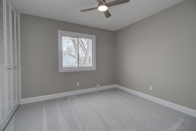 unfurnished bedroom with a closet, baseboards, and light carpet