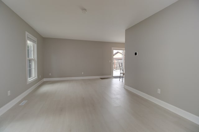 spare room with baseboards, visible vents, and light wood-type flooring