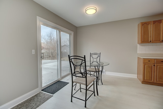 dining area with light wood-style floors and baseboards