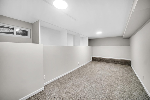 finished below grade area featuring baseboards and carpet