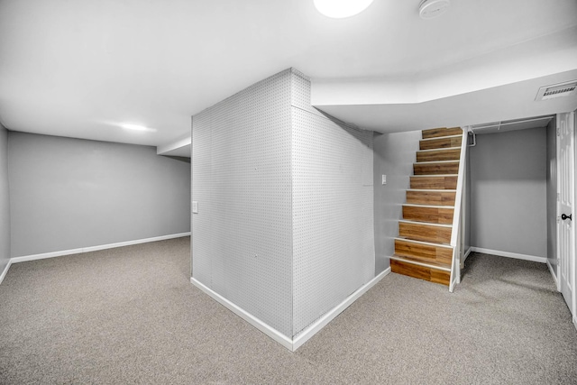 finished basement with carpet, stairs, baseboards, and visible vents