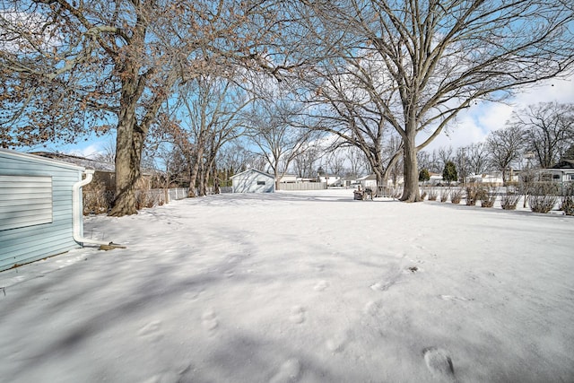 yard covered in snow featuring fence
