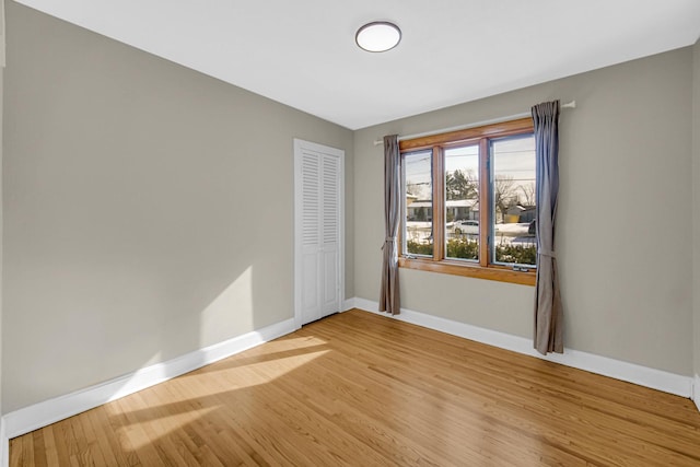 empty room featuring light wood finished floors and baseboards