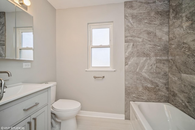 full bath with toilet, vanity,  shower combination, and baseboards