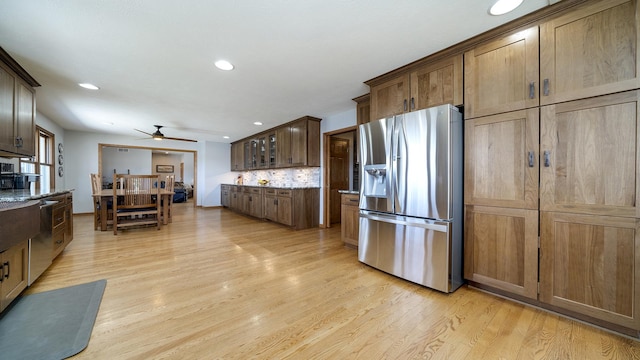 kitchen featuring recessed lighting, a ceiling fan, light wood-type flooring, light stone countertops, and appliances with stainless steel finishes
