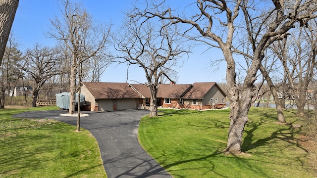 ranch-style house with an attached garage, driveway, and a front yard