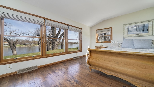 bedroom with baseboards, dark wood-type flooring, vaulted ceiling, and visible vents