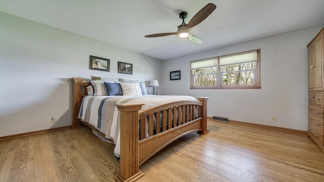 bedroom with baseboards, light wood-style flooring, visible vents, and a ceiling fan