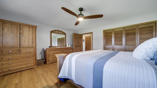 bedroom featuring light wood-style floors, visible vents, and ceiling fan