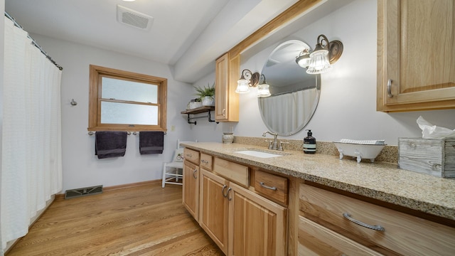bathroom with wood finished floors, visible vents, vanity, and baseboards