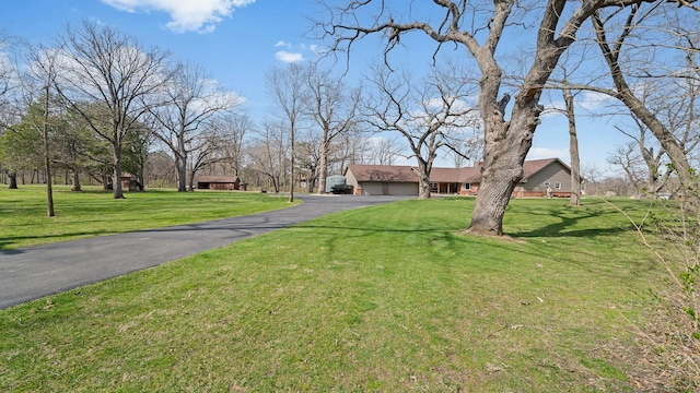 view of front facade featuring a front lawn and aphalt driveway