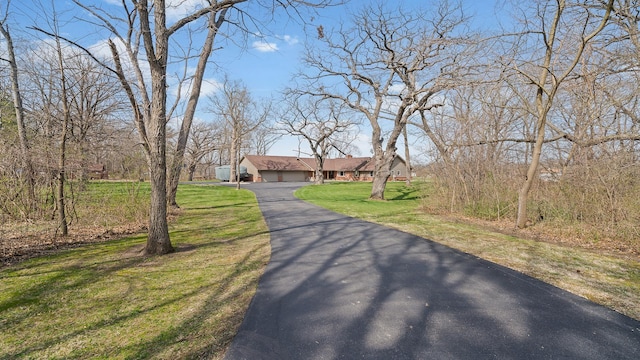 view of front of property featuring a front lawn, driveway, and a garage
