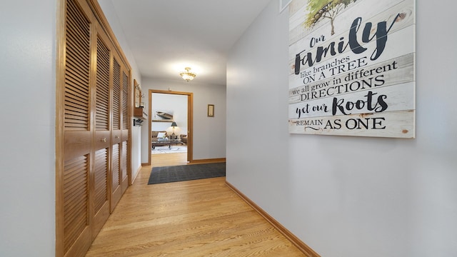 corridor featuring baseboards and wood finished floors