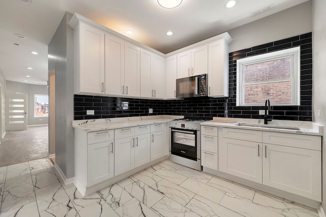 4819 W Superior St, Chicago, IL 60644 - kitchen featuring black microwave, white range with gas stovetop, a sink, light marble finish flooring, and baseboards