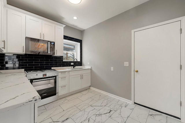 4819 W Superior St, Chicago, IL 60644 - kitchen featuring gas range gas stove, black microwave, a sink, backsplash, and white cabinetry