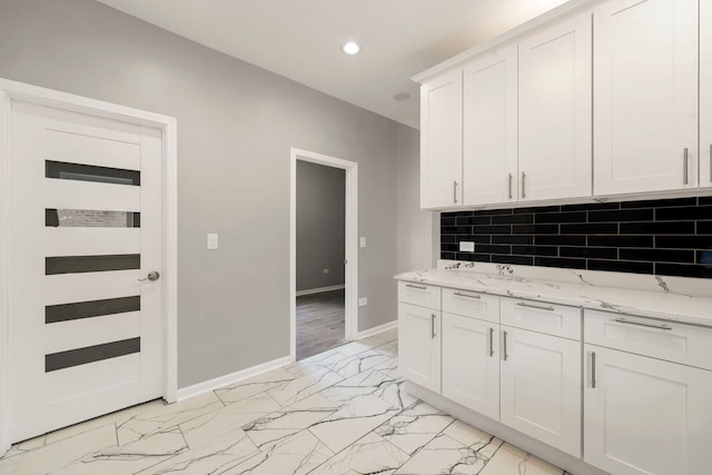 4819 W Superior St, Chicago, IL 60644 - kitchen with recessed lighting, light marble finish flooring, baseboards, white cabinets, and light stone countertops