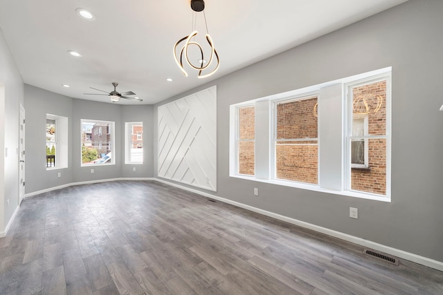 4819 W Superior St, Chicago, IL 60644 - unfurnished living room featuring a ceiling fan, baseboards, dark wood-style flooring, recessed lighting, and a chandelier