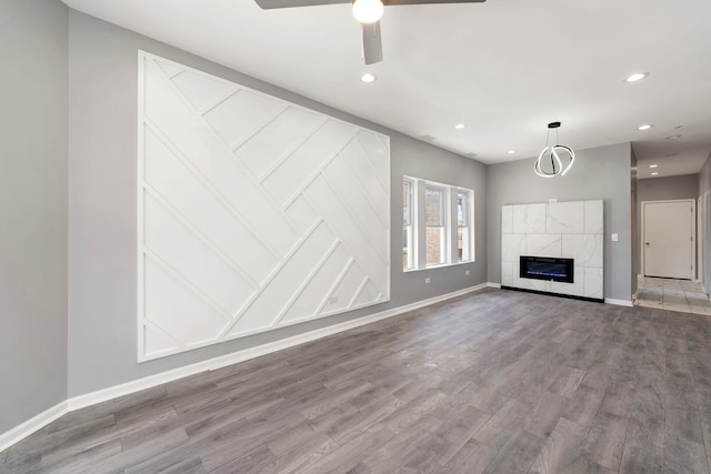 4819 W Superior St, Chicago, IL 60644 - unfurnished living room featuring baseboards, recessed lighting, wood finished floors, ceiling fan, and a tiled fireplace