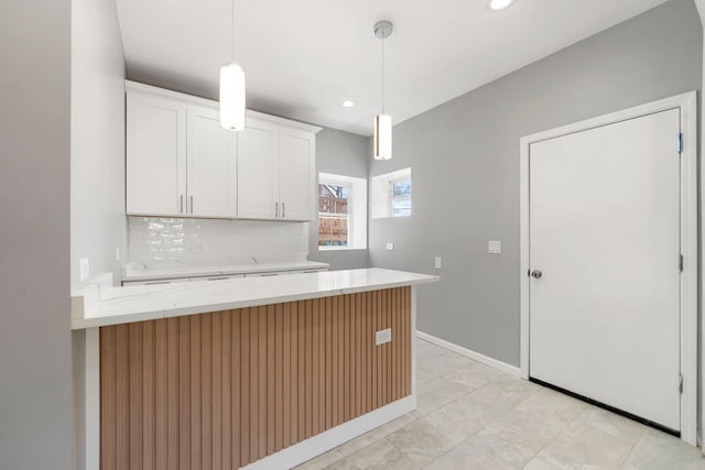 4819 W Superior St, Chicago, IL 60644 - kitchen with white cabinets, light stone countertops, pendant lighting, recessed lighting, and a peninsula