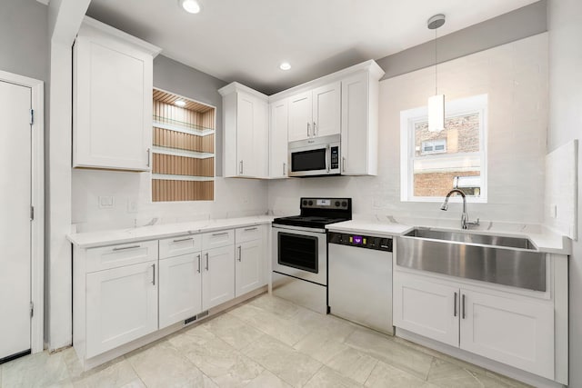4819 W Superior St, Chicago, IL 60644 - kitchen with appliances with stainless steel finishes, a sink, white cabinetry, decorative light fixtures, and recessed lighting