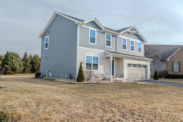 view of front of home with a front lawn, aphalt driveway, central air condition unit, and a garage