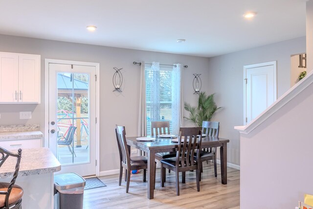 dining room featuring baseboards, light wood-style floors, and recessed lighting