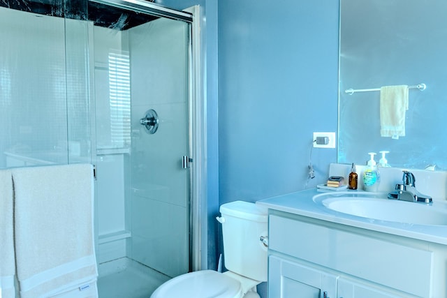 bathroom with vanity, toilet, and a stall shower