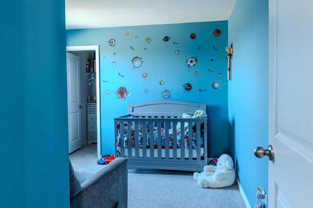 carpeted bedroom with a nursery area