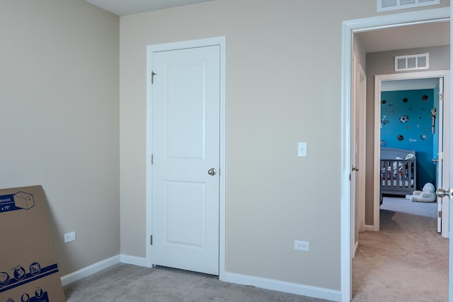 unfurnished bedroom with light carpet, baseboards, and visible vents