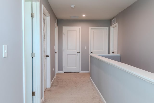 hall with recessed lighting, baseboards, visible vents, and light colored carpet