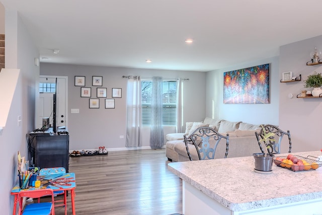living room with baseboards, recessed lighting, and light wood-style floors