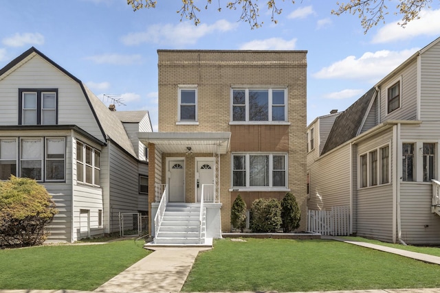 view of front facade featuring brick siding and a front yard
