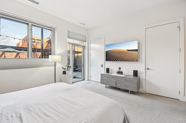 bedroom with carpet floors, visible vents, and access to exterior