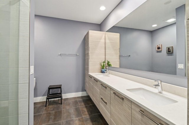 bathroom featuring a sink, tile patterned floors, baseboards, and double vanity