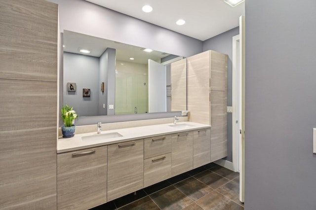 full bath featuring a sink, tile patterned floors, a shower stall, and double vanity