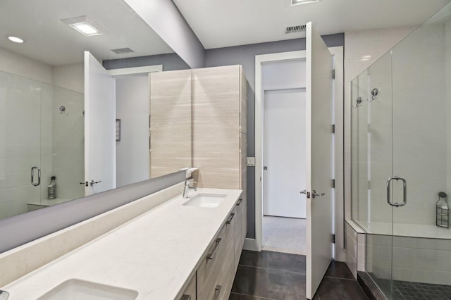 full bathroom with visible vents, a sink, a stall shower, and tile patterned flooring