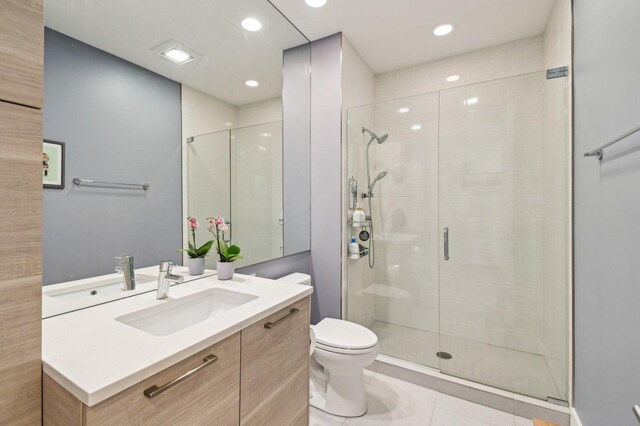 bathroom with vanity, recessed lighting, toilet, and a shower stall