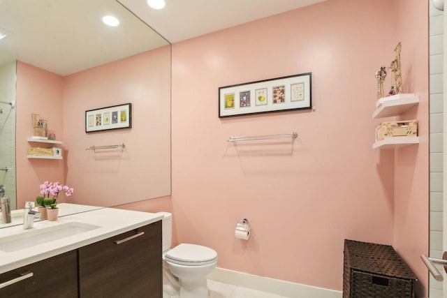 bathroom with vanity, a shower, toilet, baseboards, and recessed lighting
