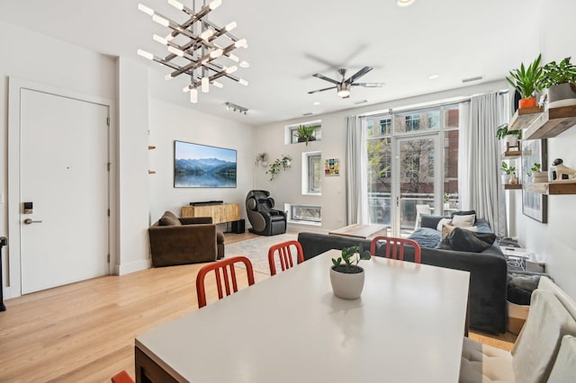 dining space with recessed lighting, ceiling fan with notable chandelier, light wood-type flooring, and visible vents
