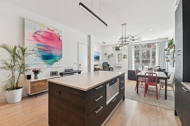 kitchen featuring light countertops, light wood-style flooring, modern cabinets, and dark brown cabinets