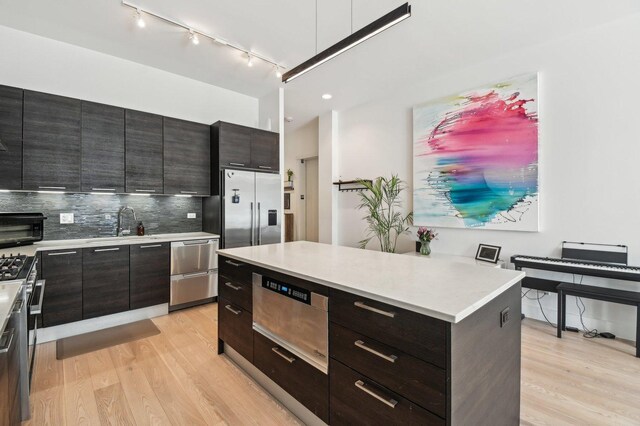 kitchen featuring high quality appliances, modern cabinets, and light wood finished floors