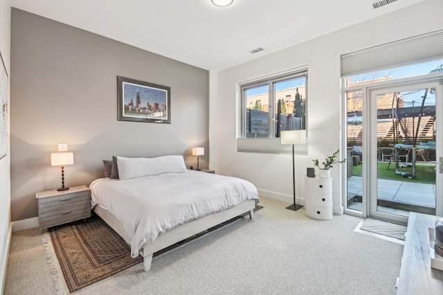 carpeted bedroom featuring baseboards, visible vents, and access to exterior