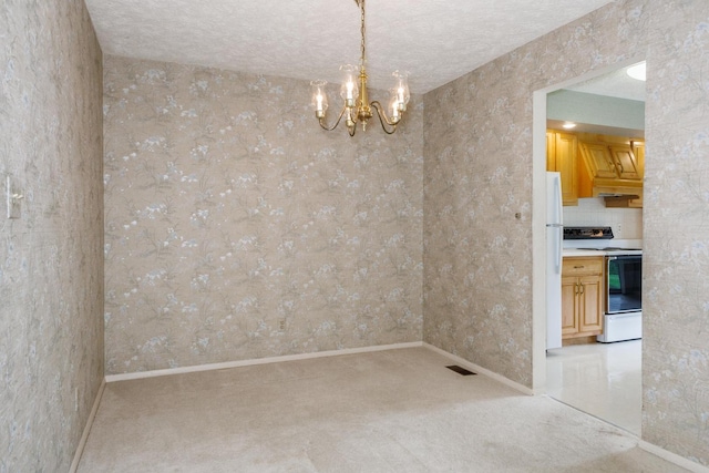 unfurnished dining area with an inviting chandelier, carpet floors, baseboards, and visible vents