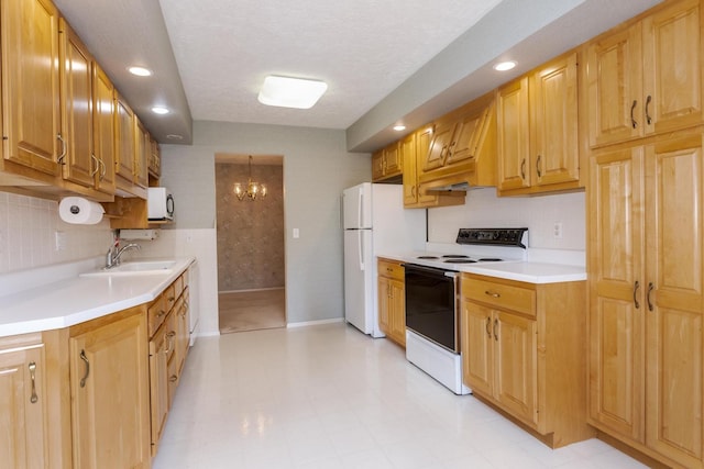 kitchen with a sink, backsplash, white appliances, and light countertops