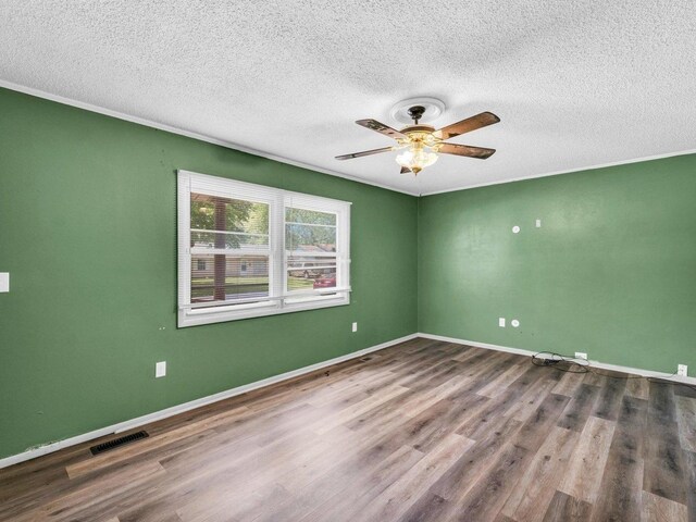 1045 Briarcliff Dr, Rantoul, IL 61866 - unfurnished room featuring a textured ceiling, wood finished floors, a ceiling fan, and baseboards