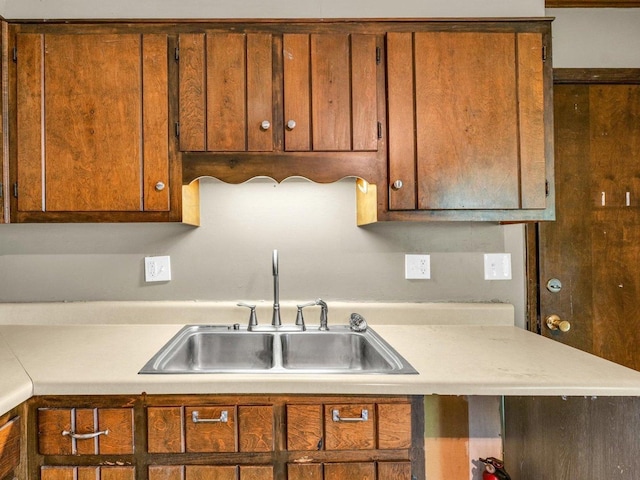 1045 Briarcliff Dr, Rantoul, IL 61866 - kitchen with a sink, light countertops, and brown cabinets