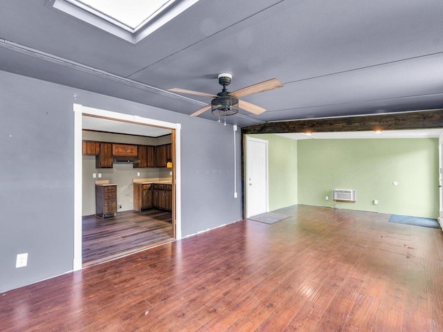 1045 Briarcliff Dr, Rantoul, IL 61866 - unfurnished living room with wood finished floors, a wall mounted air conditioner, ceiling fan, and a skylight